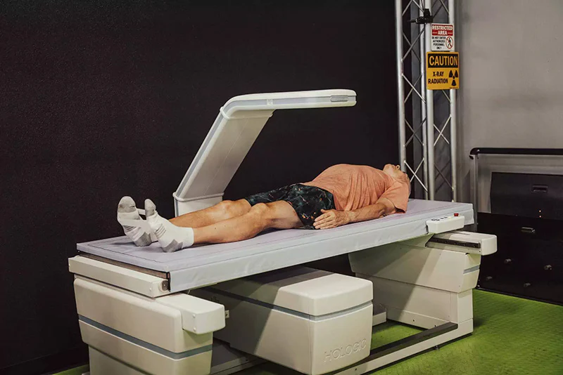 A person lies on a DEXA scan machine